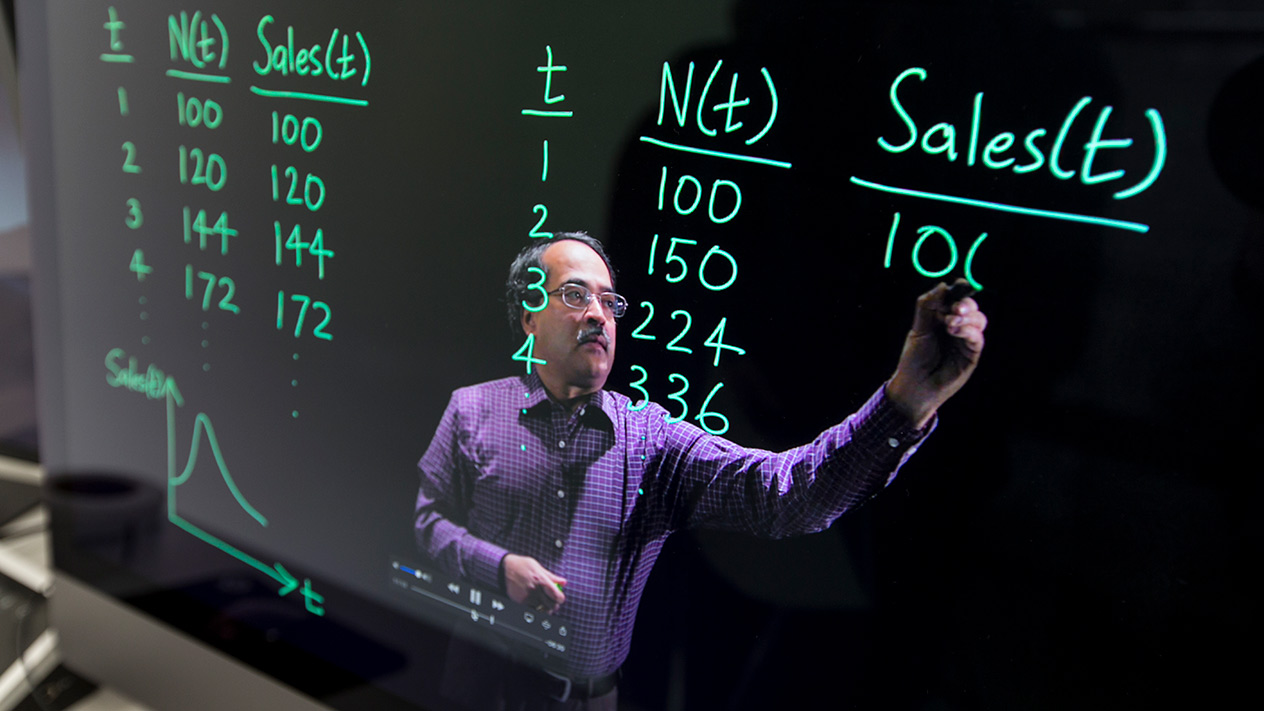 Teacher educating students on Business Analytics for Olin