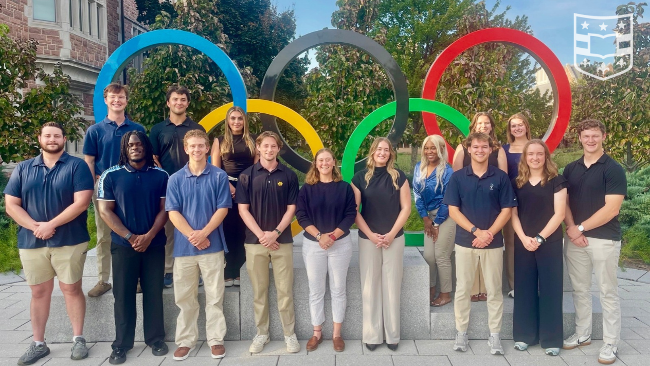 Students standing in front of the Olympic Rings