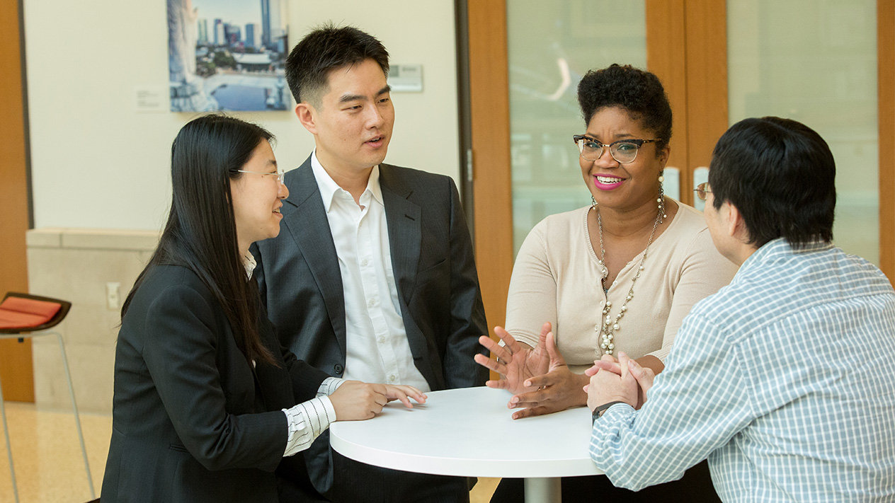 DBA students in a small group discussion on campus.