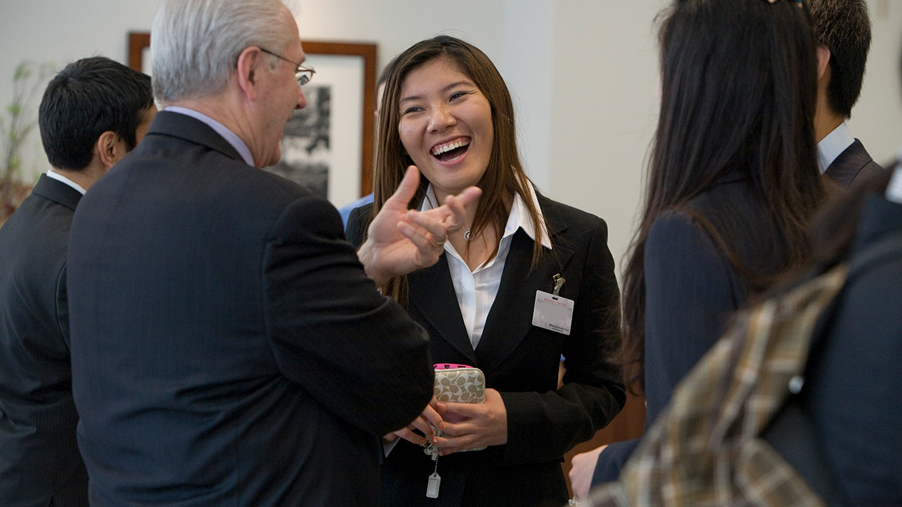 Group of students gathered in a common area to discuss the MS in Corporate Finance Program