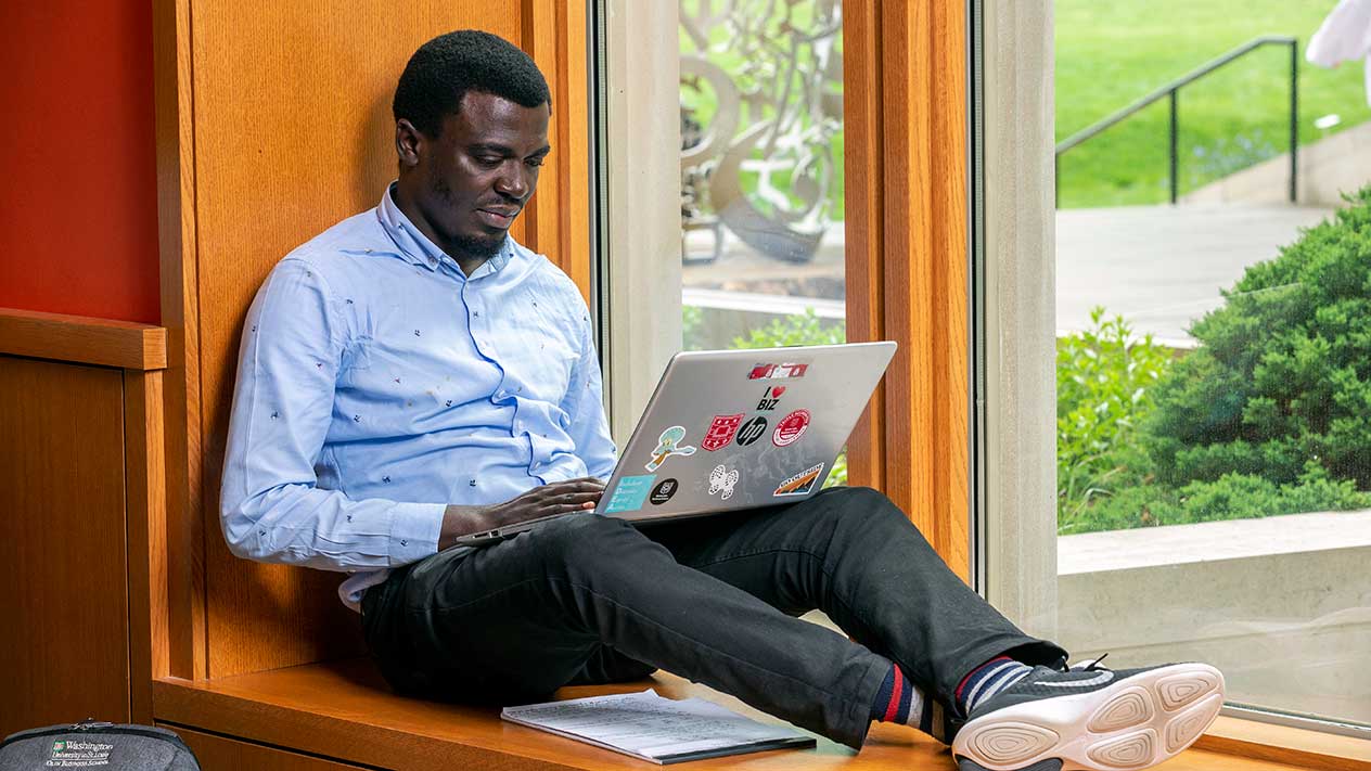 Student doing Online MS in Finance course work on laptop