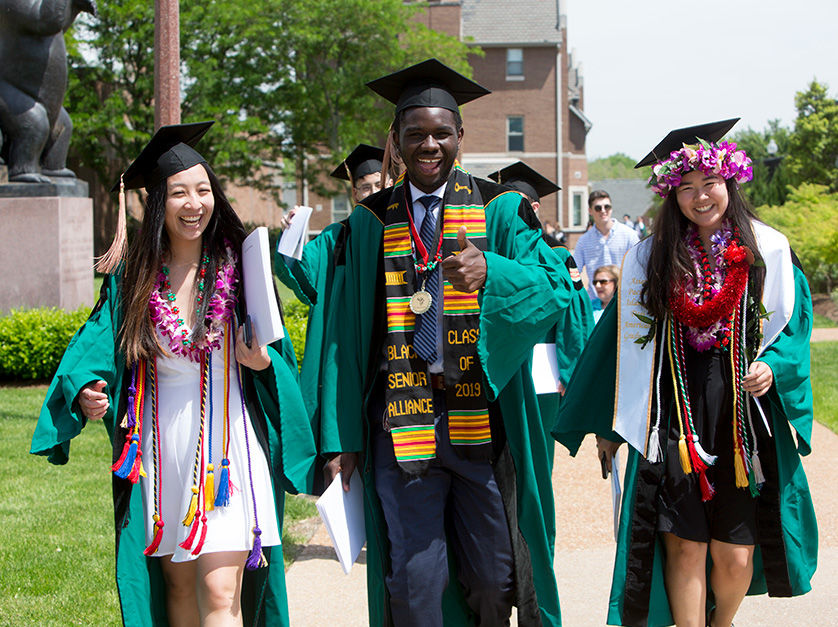 Three smiling BSBA graduates leaving Olin's commencement ceremony.