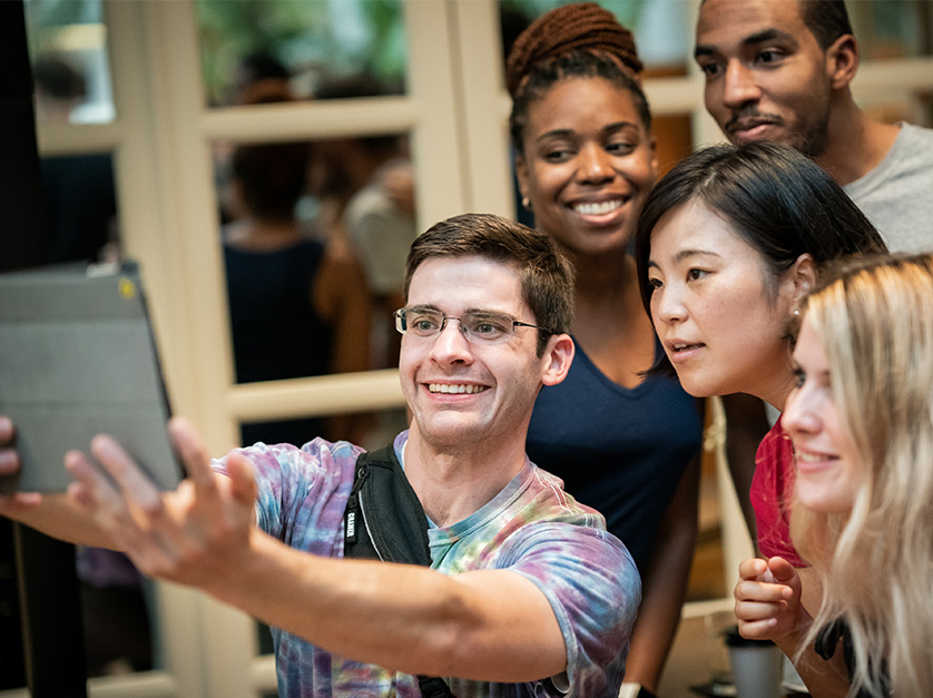 New MBA students taking a selfie while working on their program.