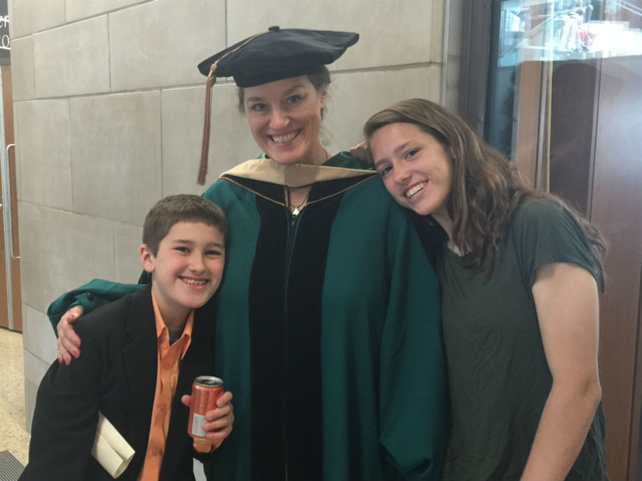 Cameron McKenzie, the author’s son, the author herself, and her daughter Maya McKenzie at the author’s EMBA graduation in May 2015.