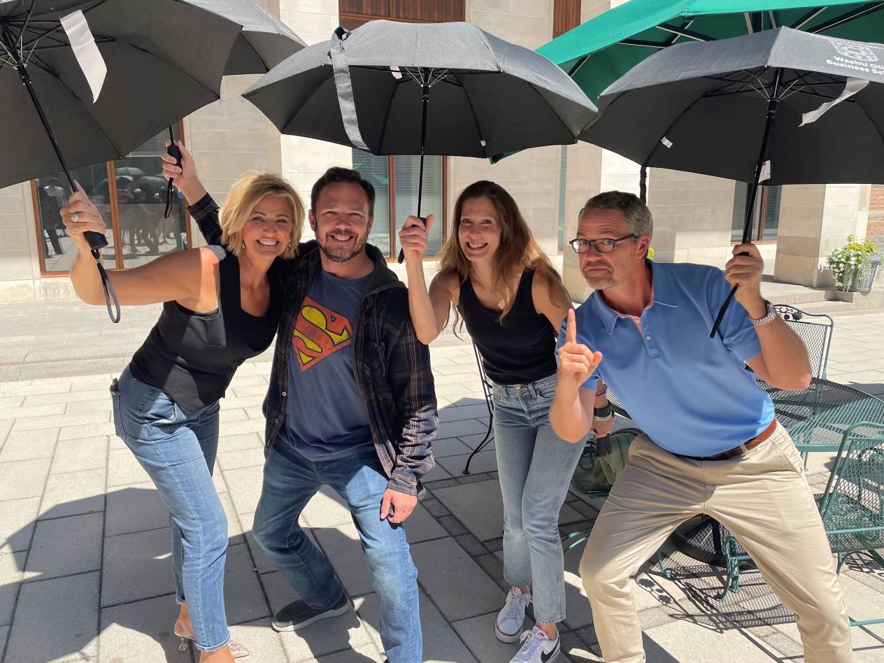 Four Olin EMBA students holding umbrellas