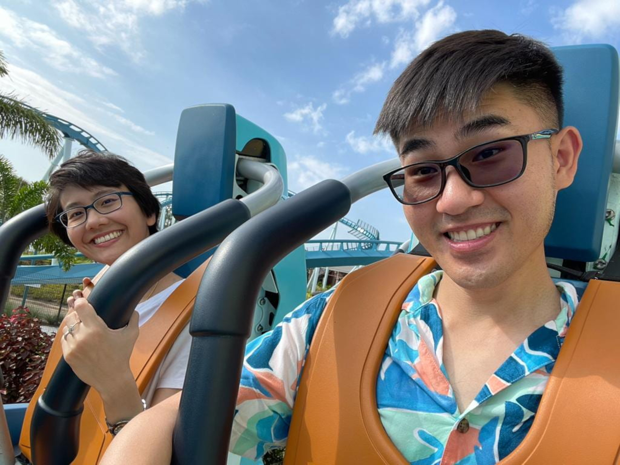 A woman and a man seated in a roller coaster