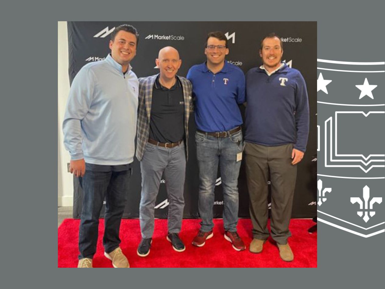 Four men standing on a red carpet