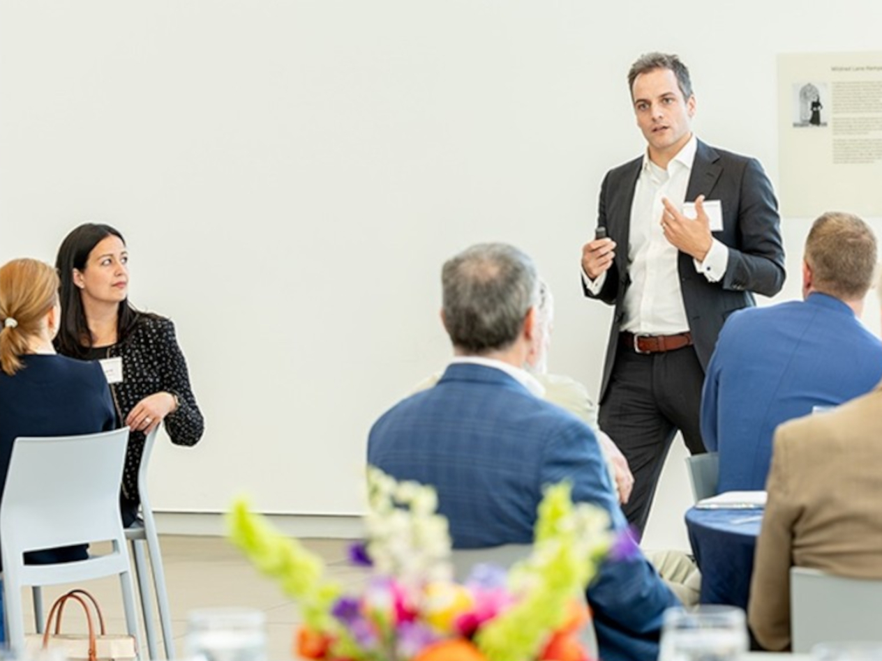 Peter Boumgarden presents at an event as Margaret Schnuck Rogers (left) listens.