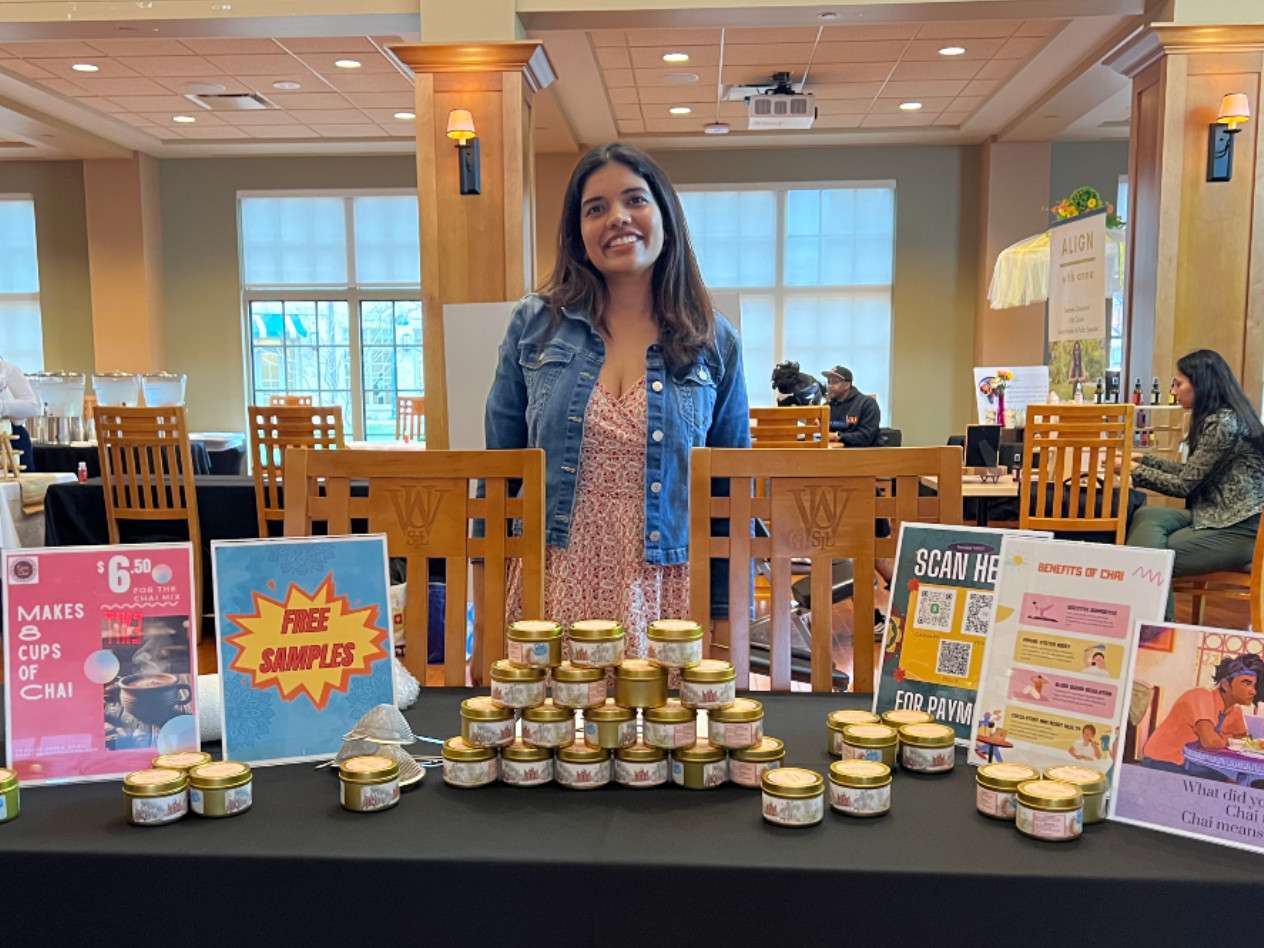 Woman standing with table full of products