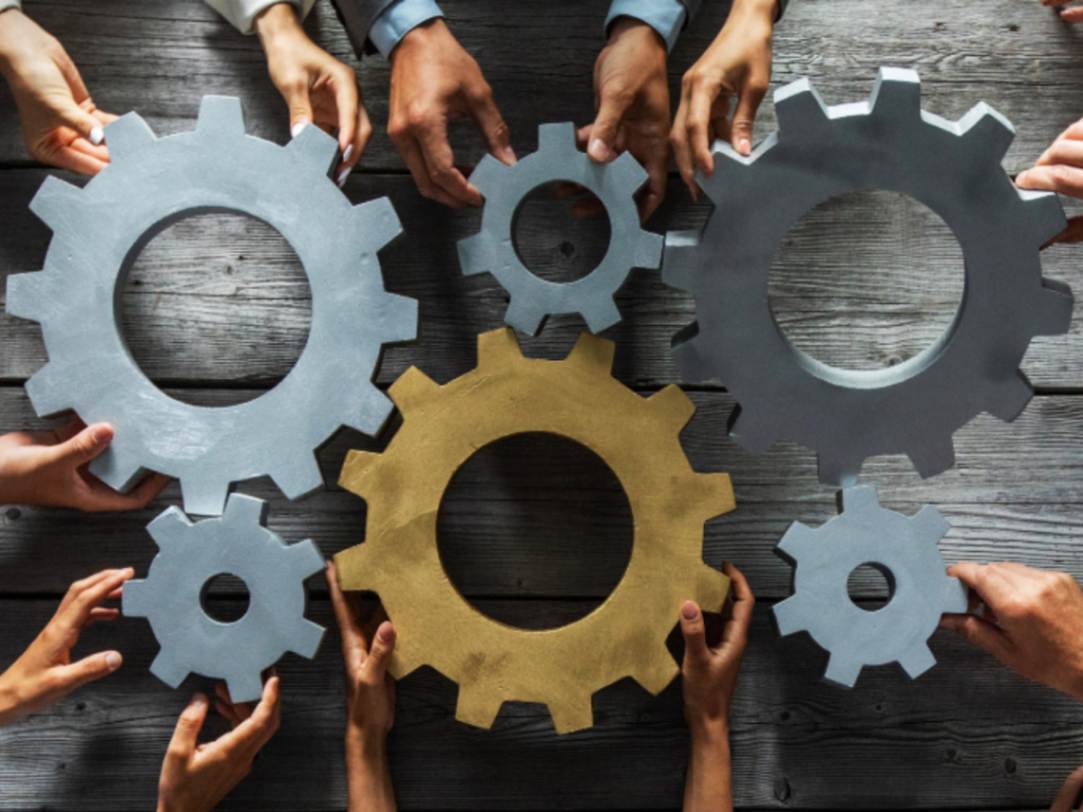 hands holding cogs and fitting them together