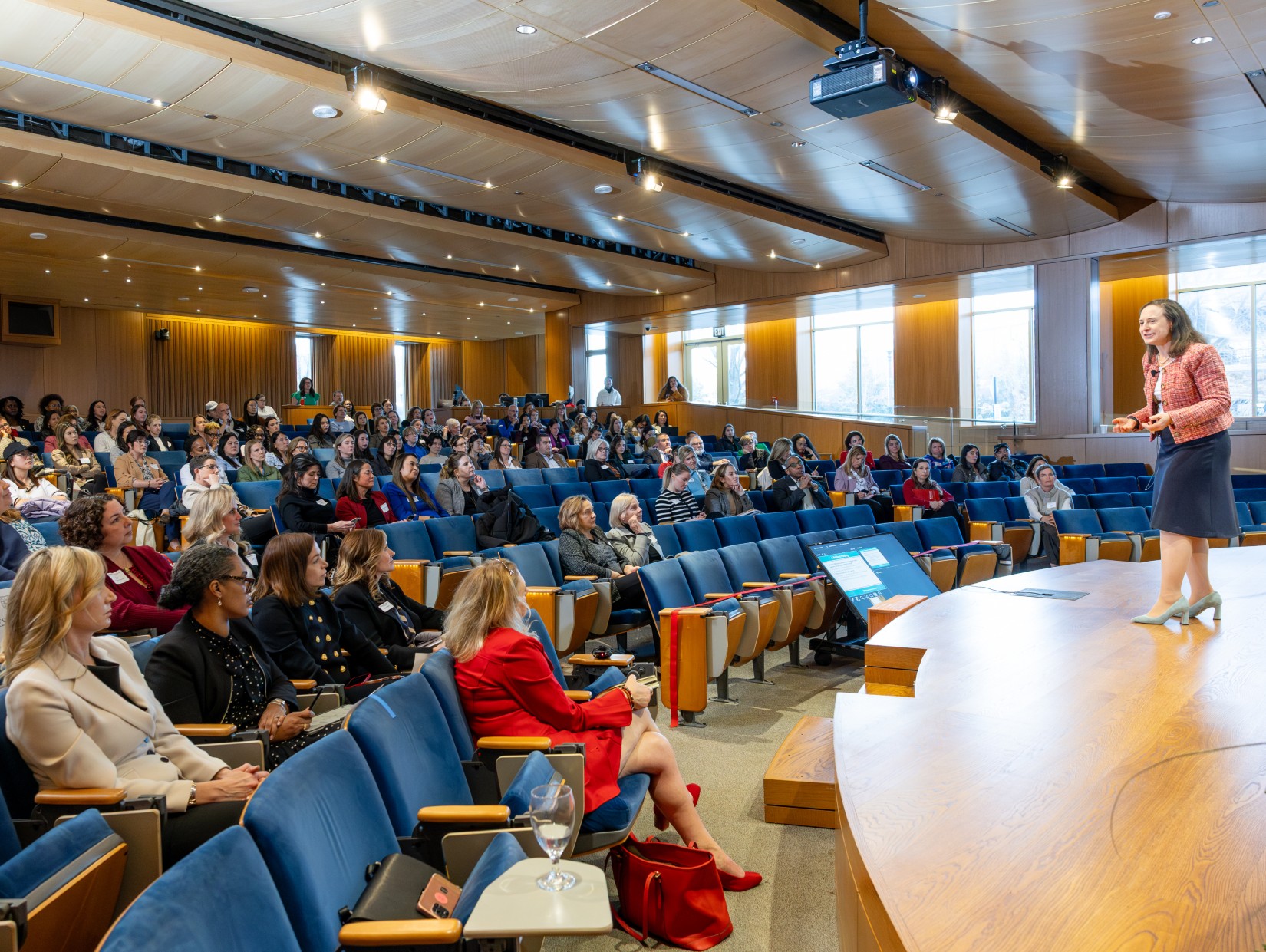 A woman on a stage addresses an auditorium