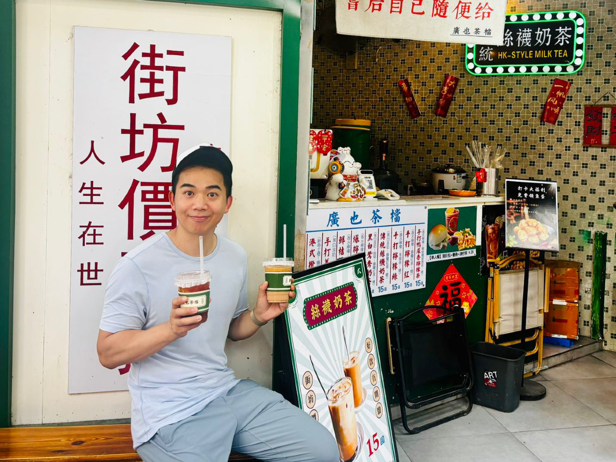 Xin Wei holds up two drinks